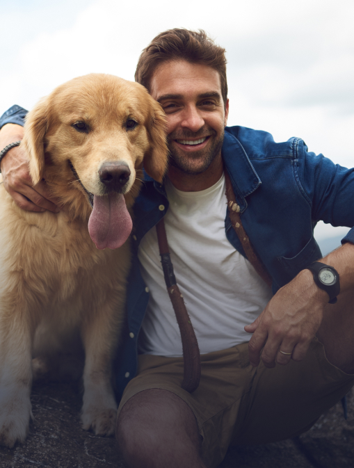 A man is looking at his phone with his dog